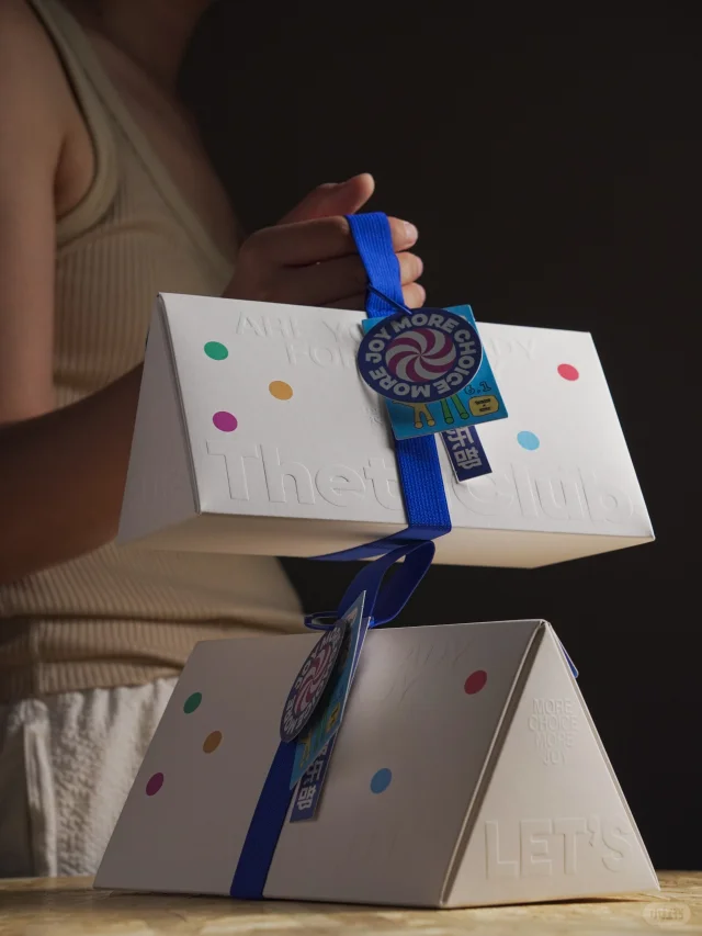 Triangular magnetic flip-top gift box with ribbon handle and embossed text, custom premium packaging